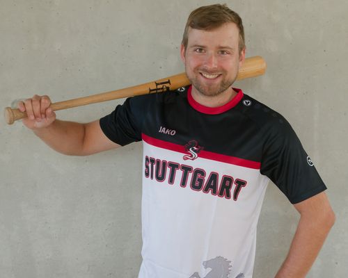 Mann präsentiert das schwarz-rot-weiße Gewinnertrikot des TVC Fantrikot Battles 2026