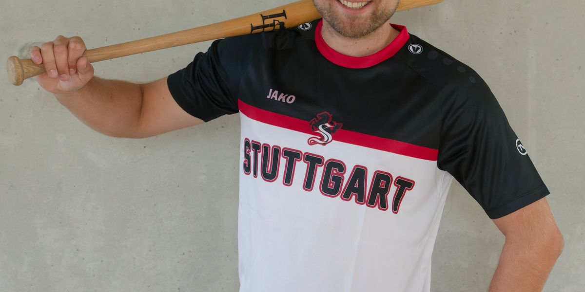 Mann präsentiert das schwarz-rot-weiße Gewinnertrikot des TVC Fantrikot Battles 2026