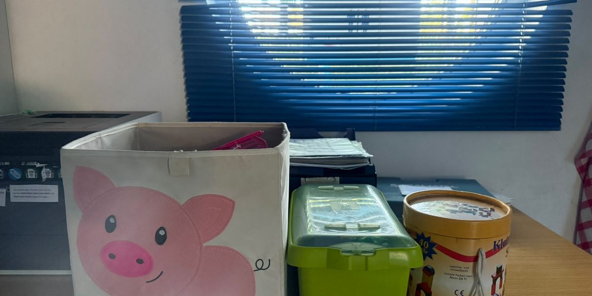 Spielmaterial für das Spielzimmer mit Aufbewahrungsboxen, Spielen und Bausteinen.